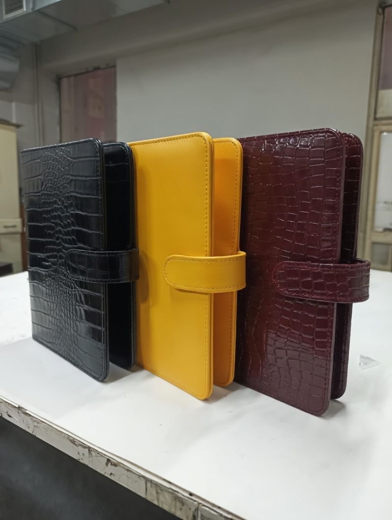 Three croc-embossed leather diaries side by side