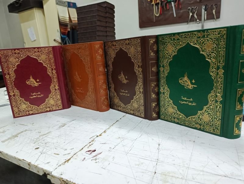 Emblem tooled leather binding covers arranged by colour