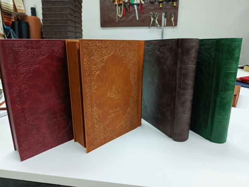 Burgundy, tan and green tooled leather menu covers side by side