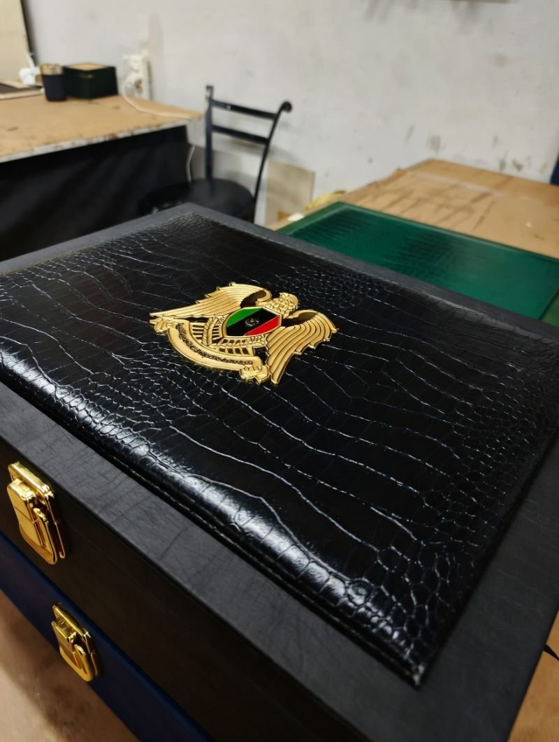 Croc-embossed black leather box with gold emblem